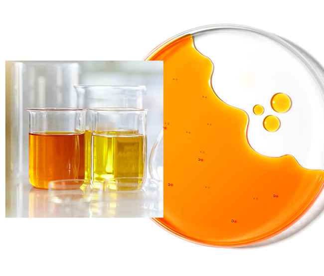 Image shows orange liquid in a large glass beaker and yellow liquid in a large glass beaker and next this this is a petri dish with orange liquid in and three drops to the side.